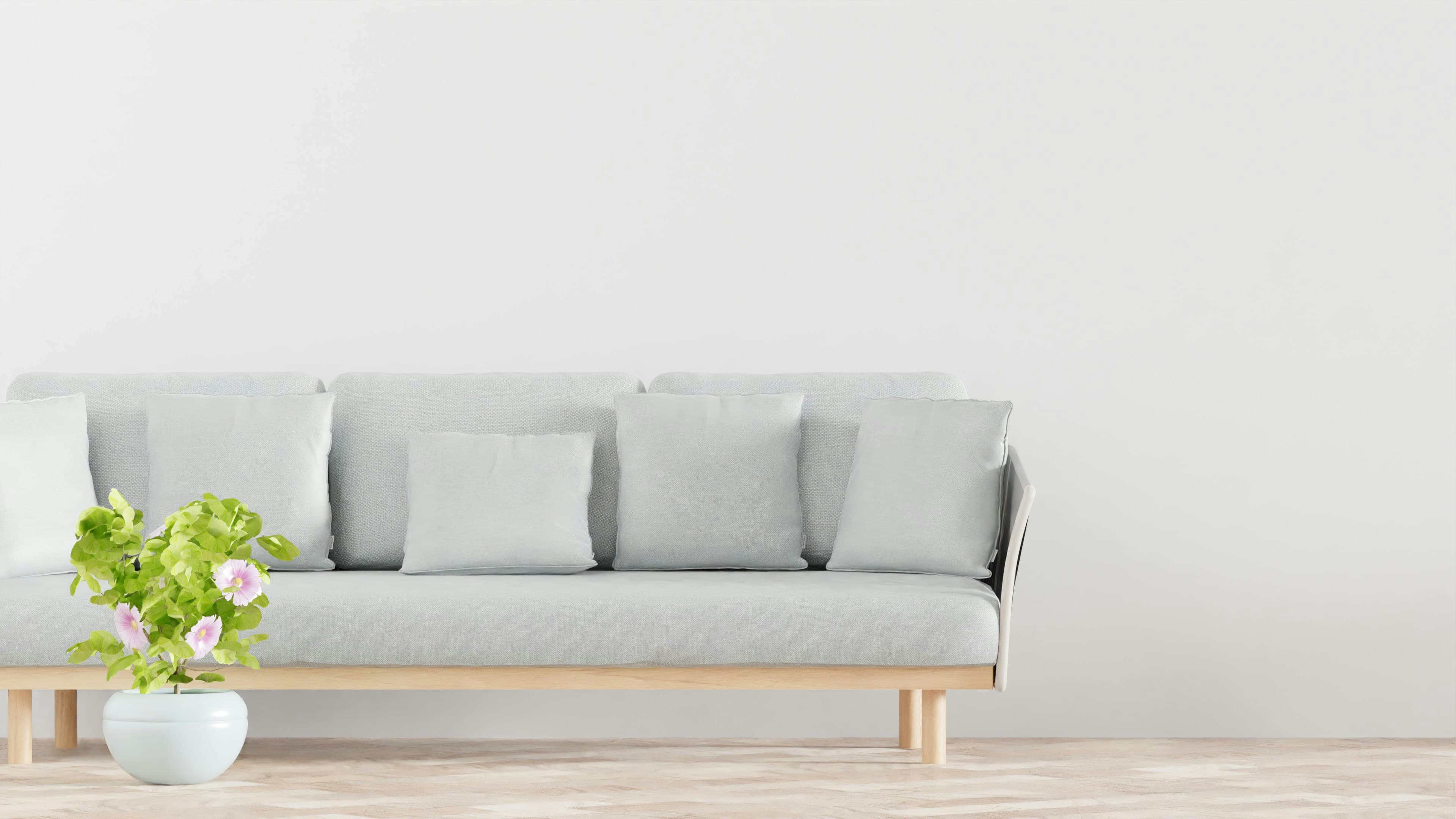 A plant and sofa complement the minimalist flooring.