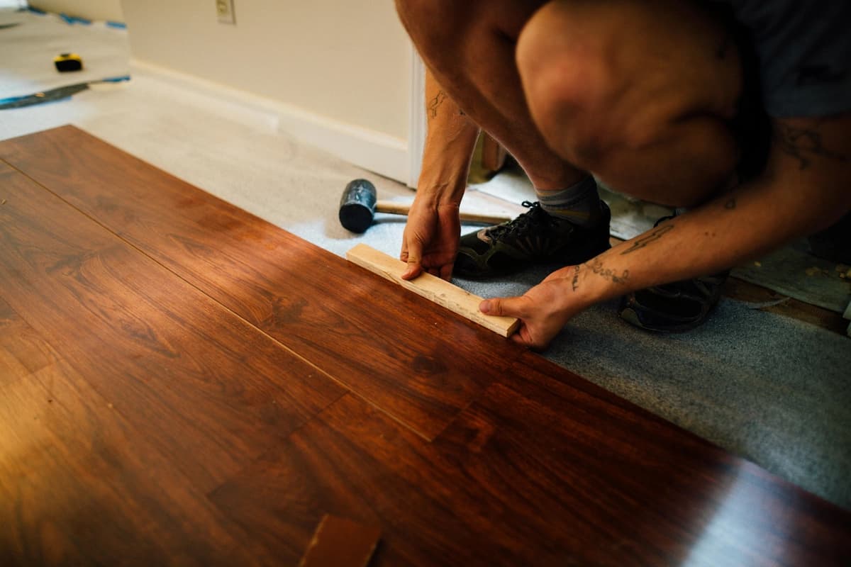 an installer adjusting dark hickory flooring