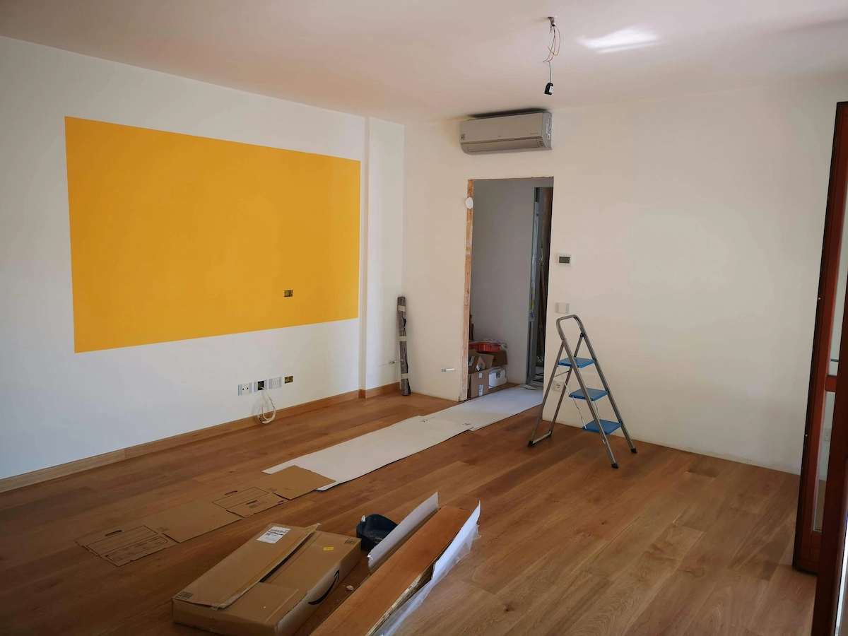 A room with new flooring being installed including tools and opened boxes of flooring